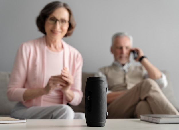 Foto gratuita pareja feliz de tiro medio con altavoz