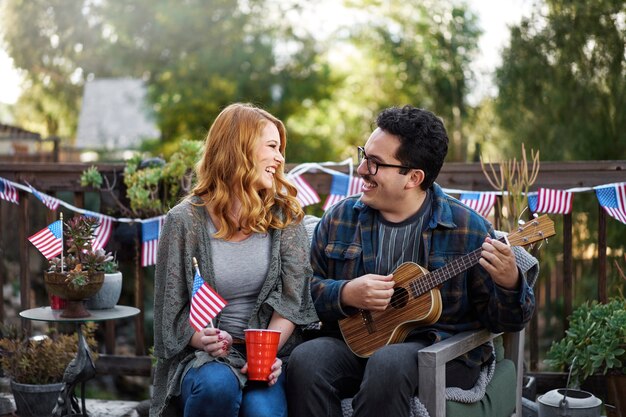 Pareja feliz de tiro medio con bandera americana