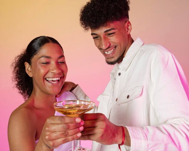 Pareja feliz de tiro medio celebrando con bebidas