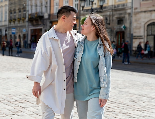 Pareja feliz de tiro medio en la ciudad