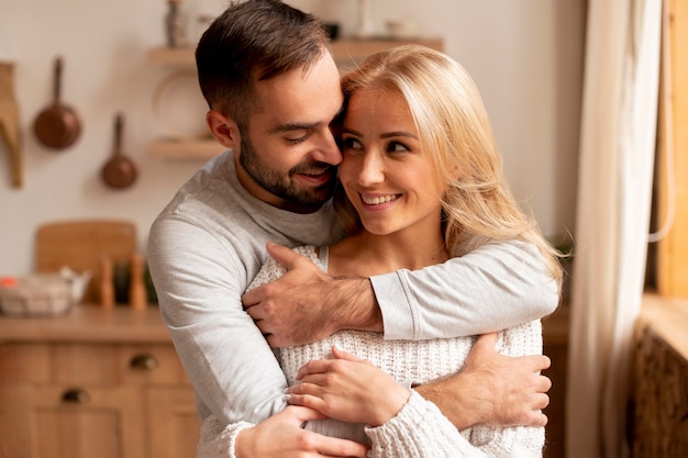 Pareja feliz de tiro medio en la cocina