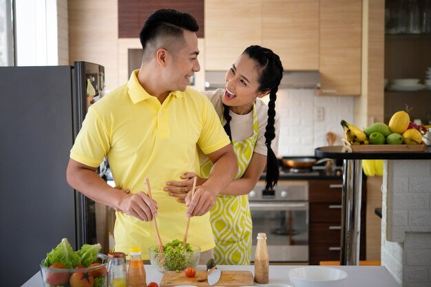 Pareja feliz de tiro medio en la cocina la