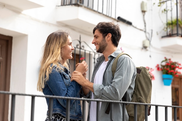 Foto gratuita pareja feliz de tiro medio con flor