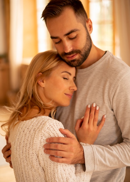 Pareja feliz de tiro medio en el interior