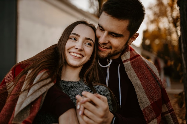 Foto gratuita pareja feliz de tiro medio con manta