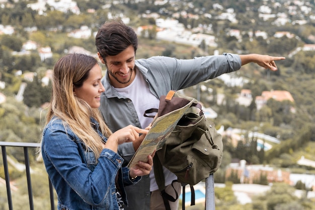 Foto gratuita pareja feliz de tiro medio con mapa