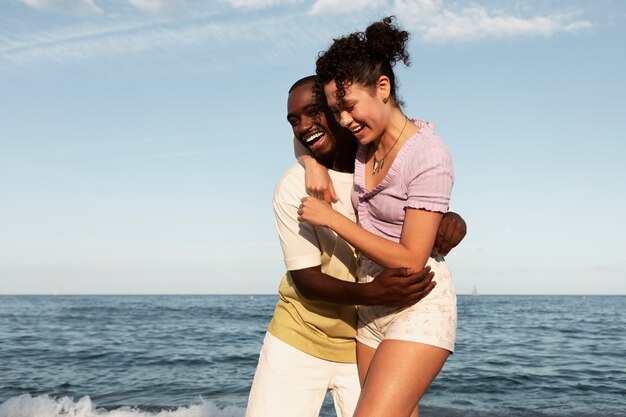 Pareja feliz de tiro medio en el mar