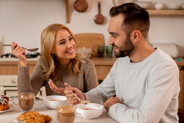 Pareja feliz de tiro medio en la mesa