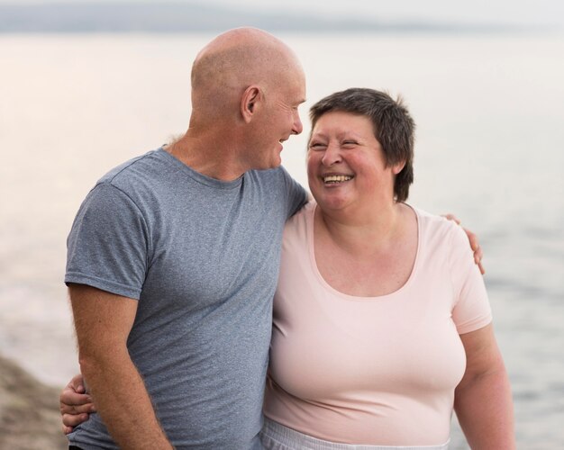 Pareja feliz de tiro medio en la playa