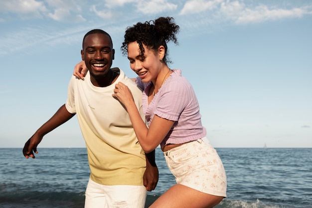 Pareja feliz de tiro medio en la playa