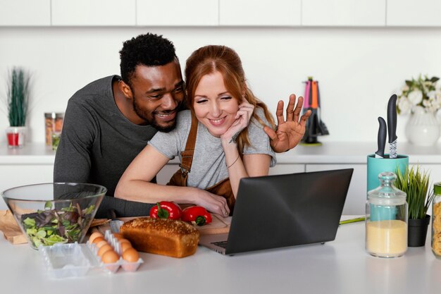 Pareja feliz de tiro medio con portátil