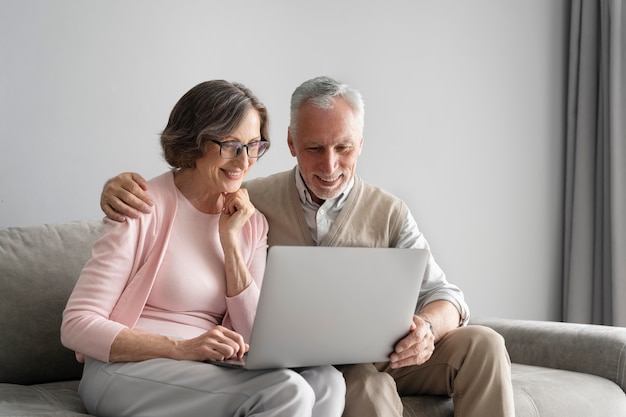 Pareja feliz de tiro medio con portátil