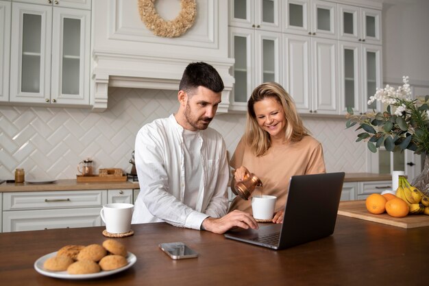 Foto gratuita pareja feliz de tiro medio con portátil