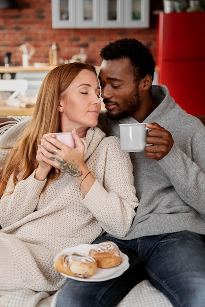 Pareja feliz de tiro medio con tazas