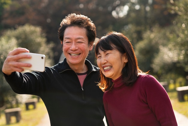 Pareja feliz de tiro medio tomando selfie