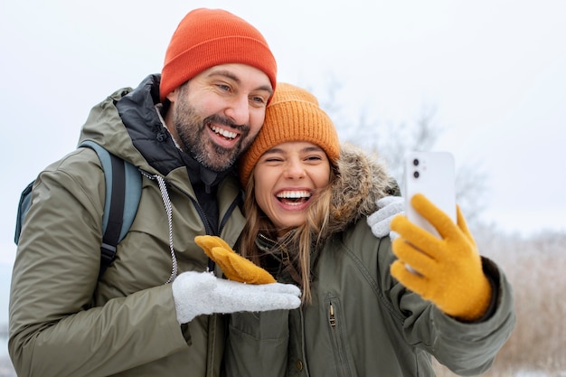 Pareja feliz de tiro medio tomando selfie