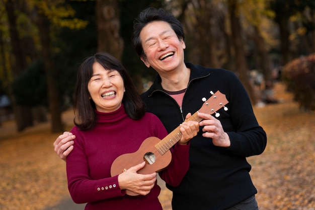 Pareja feliz de tiro medio con ukelele