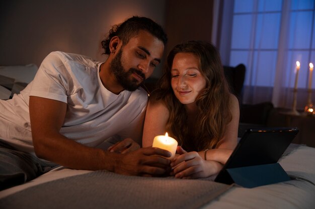 Pareja feliz de tiro medio con vela