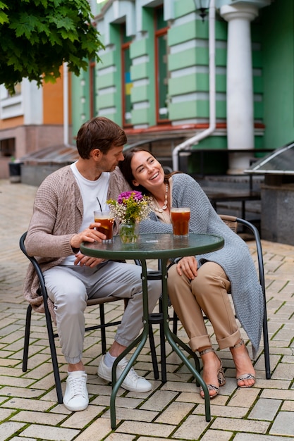 Una pareja feliz tomando bebidas en una terraza