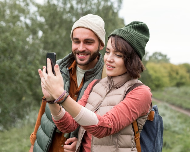 Pareja feliz tomando un selfie en la naturaleza