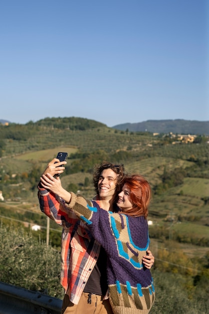 Foto gratuita pareja feliz tomando selfie tiro medio