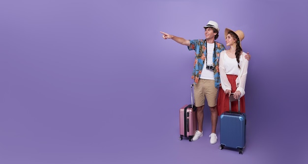 Pareja feliz turista mano apuntando a copiar espacio con equipaje que va a viajar de vacaciones