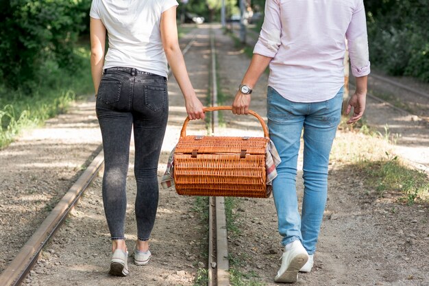 Pareja en un ferrocarril llevando una cesta de picnic