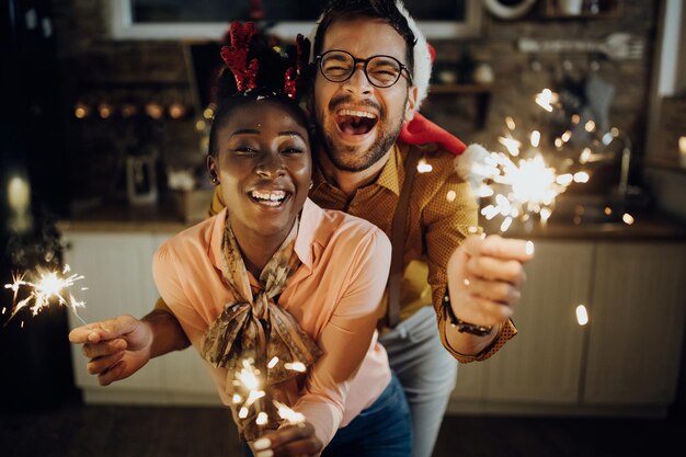 Pareja festiva divirtiéndose mientras celebra el Año Nuevo en casa