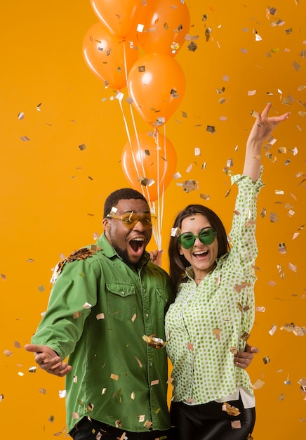 Pareja en fiesta divirtiéndose y sosteniendo globos