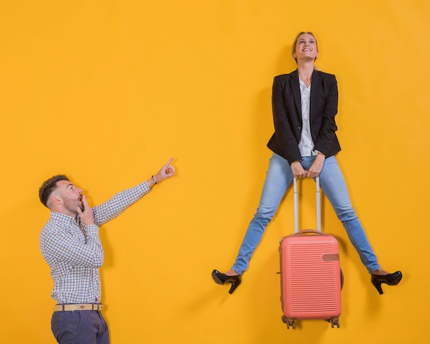 Pareja flotando con una maleta