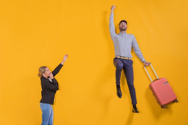 Foto gratuita pareja flotando con una maleta