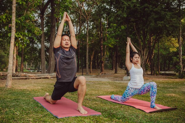 Pareja en forma estirando durante la sesión de yoga