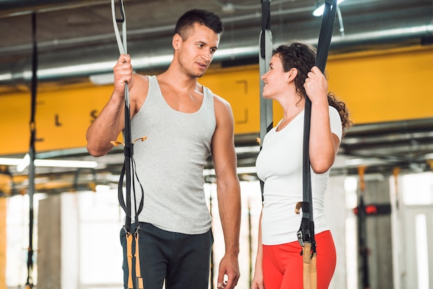 Pareja en forma mirándose en el gimnasio