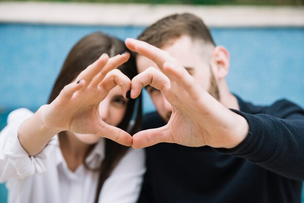 Pareja formando corazón con las manos