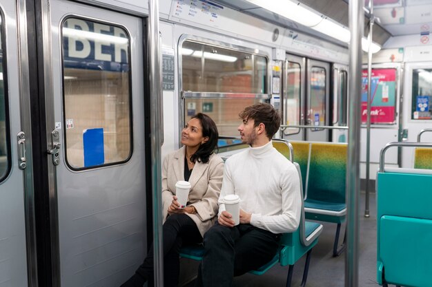 Pareja francesa montando el tren subterráneo y bebiendo café