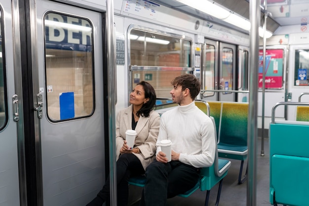 Pareja francesa montando el tren subterráneo y bebiendo café