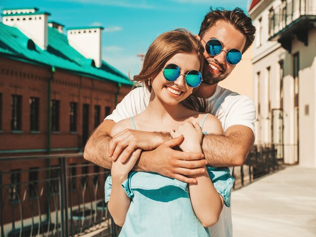 Pareja con gafas de sol posando en la calle