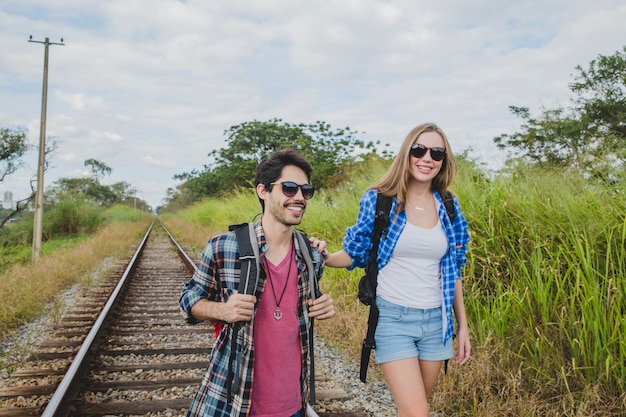 Foto gratuita pareja con gafas de sol en vías de tren