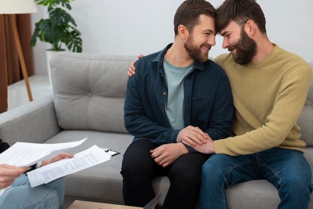 Pareja gay feliz por comprar una casa nueva de un agente inmobiliario