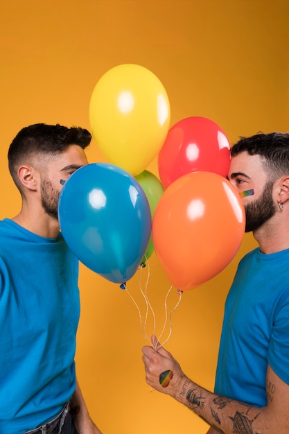 Pareja gay con globos arcoiris