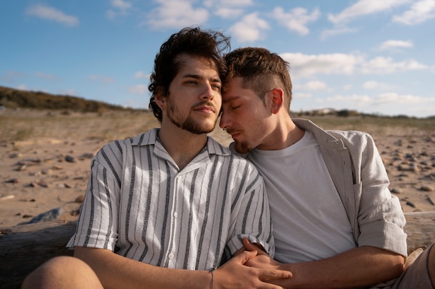 Pareja gay de plano medio en la playa