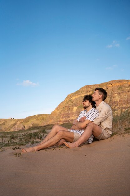 Pareja gay de tiro completo en la playa