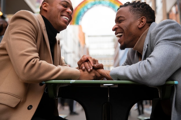 Foto gratuita una pareja gay tomados de la mano durante una cita en la ciudad