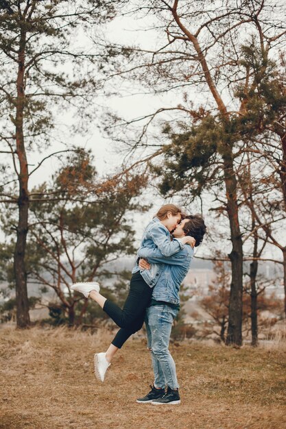 pareja gentil y elegante están dando un paseo en el parque de otoño