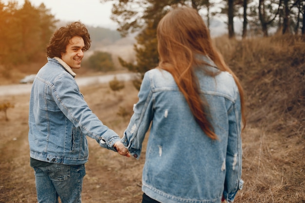 pareja gentil y elegante están dando un paseo en el parque de otoño