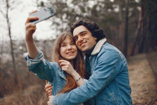 pareja gentil y elegante están dando un paseo en el parque de otoño