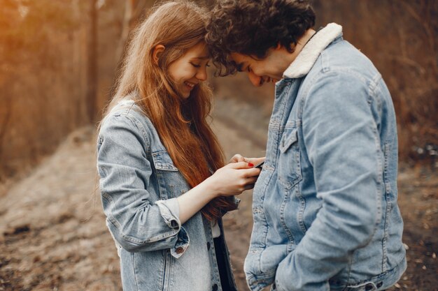 pareja gentil y elegante están dando un paseo en el parque de otoño