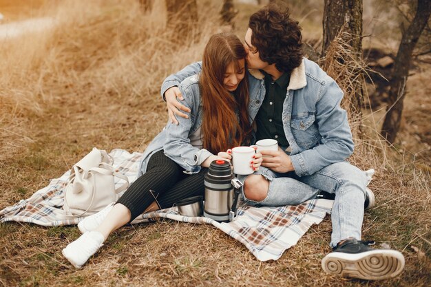 pareja gentil y elegante sentado en el parque de otoño y beber un té