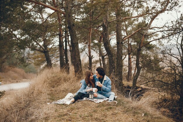 pareja gentil y elegante sentado en el parque de otoño y beber un té