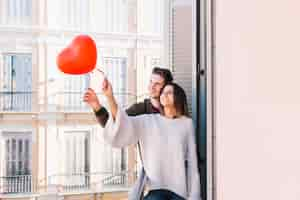 Foto gratuita pareja con globo en el balcón